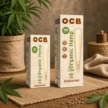 Two OCB Organic Hemp Cone packaging boxes, one 1/4 size 50 count and one 1/4 size 100 count, displayed on a rustic burlap mat with hemp leaves and a potted plant in the background.